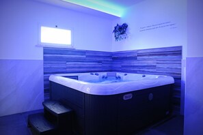 A hot tub with a wooden exterior and a small window above it. - LOUNGE PADEL VILLAGE  (Nettuno)