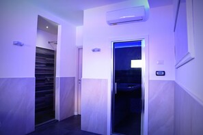 A hallway with a modern design, including a wall-mounted air conditioning unit and a door leading to a bathroom.