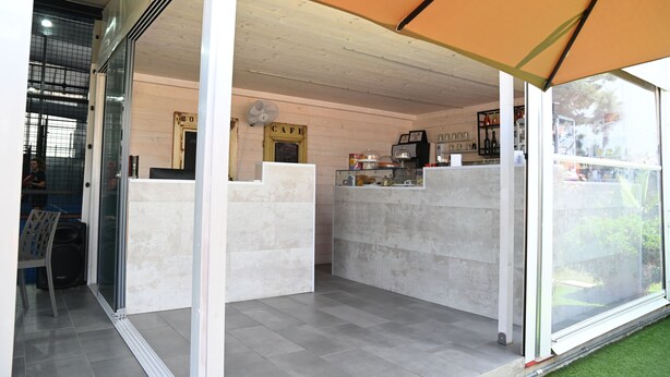Un café con una decoración moderna, que incluye una barra, un área de estar y un ventilador.