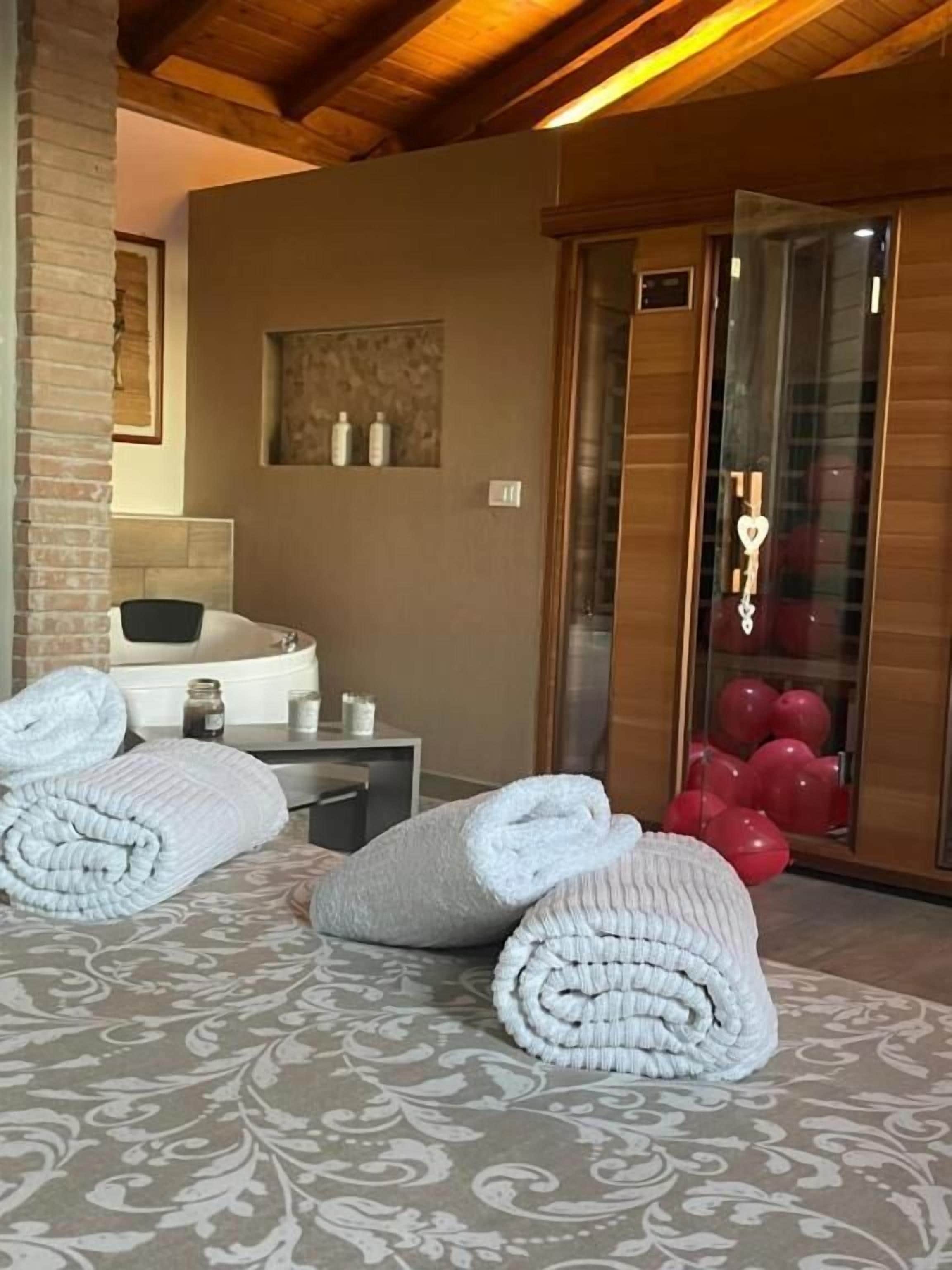 A hotel room with a bed, a bathroom, and a glass door leading to a balcony with balloons.