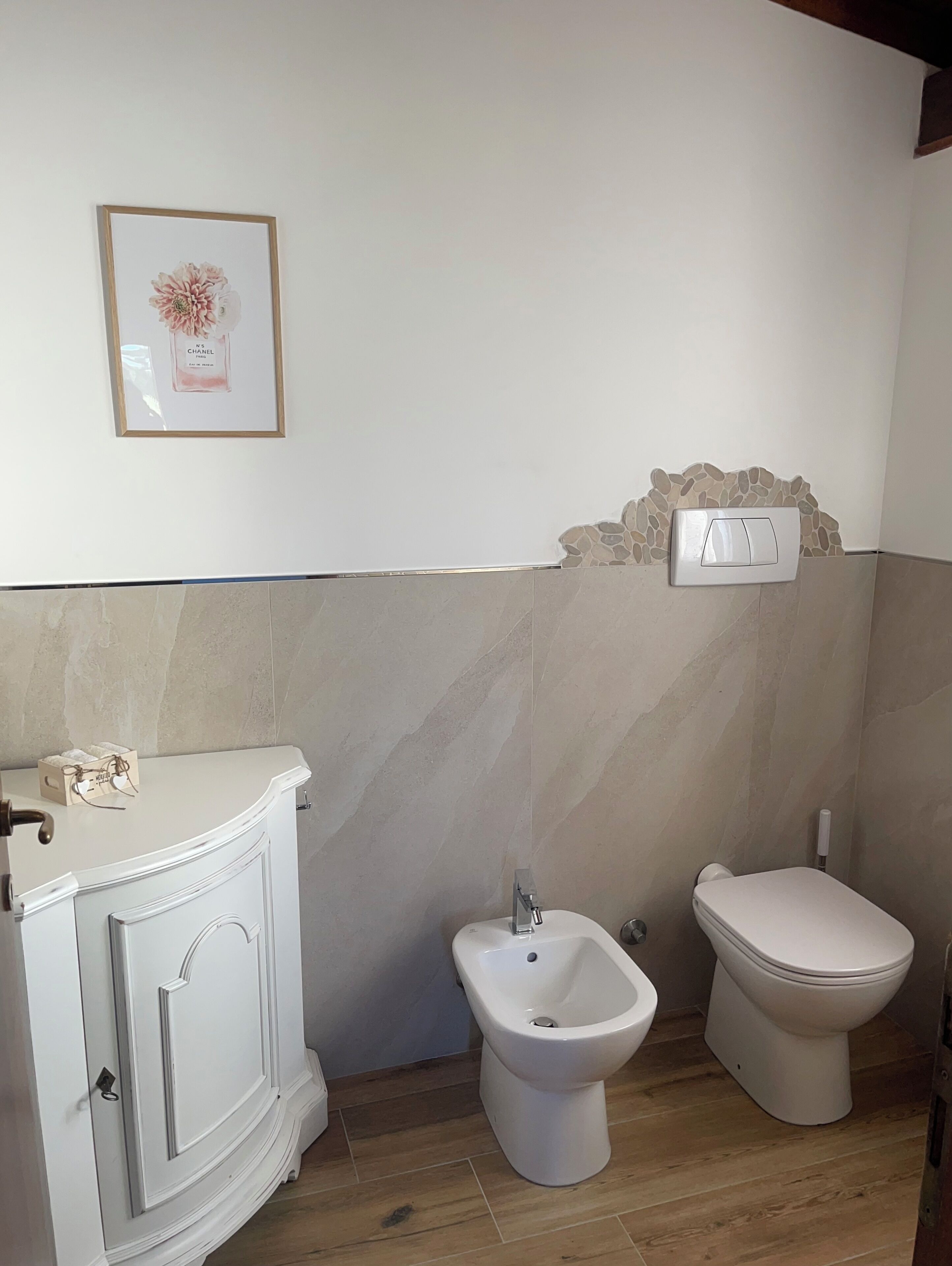 Une salle de bain avec un meuble-lavabo blanc, un bidet et des toilettes.