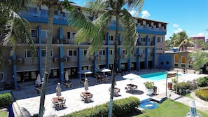 A hotel with multiple floors, outdoor pool, and dining area with umbrellas. - Apart Hotel Marinas Tamandaré Carneiros (Praia dos Carneiros)