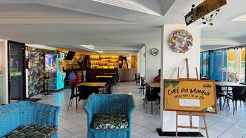 Interior de restaurante con mobiliario de mimbre, letrero de buffet y letrero de farmacia.