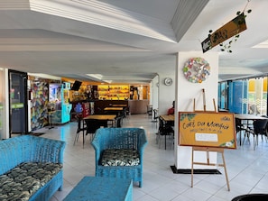A restaurant interior with wicker furniture, a buffet sign, and a pharmacy sign. - Apart Hotel Marinas Tamandaré Carneiros (Praia dos Carneiros)
