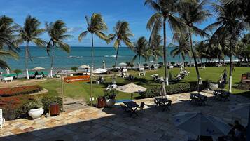 A resort with a pool, outdoor seating, and a view of the ocean.