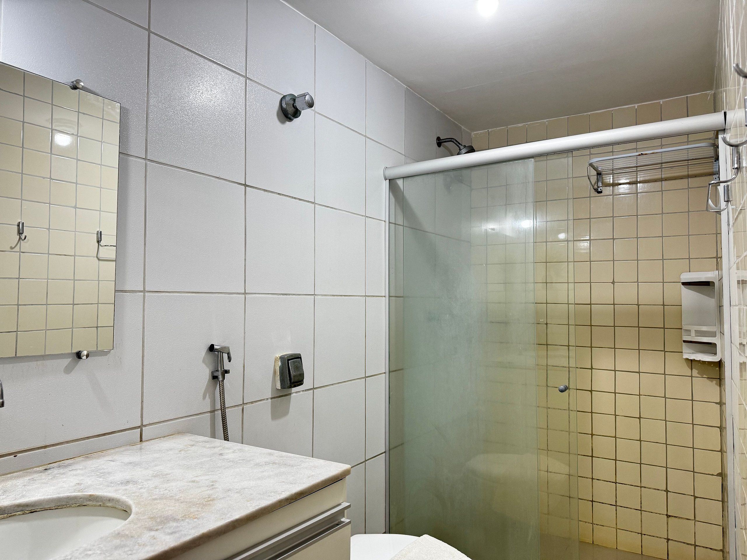 A bathroom with a shower, a sink, and a mirror.