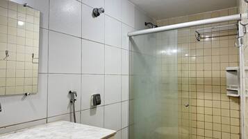 A bathroom with a shower, a sink, and a mirror.