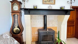 Um quarto com lareira, um relógio e um quadro na parede.