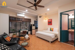 Un ambiente compatto con un letto, angolo ristoro, angolo cottura e bagno.
