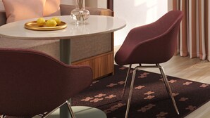 A modern dining area with a round table, two chairs, a vase with flowers, and a plate with lemons. - Numa Florence Fiesolana (Firenze)