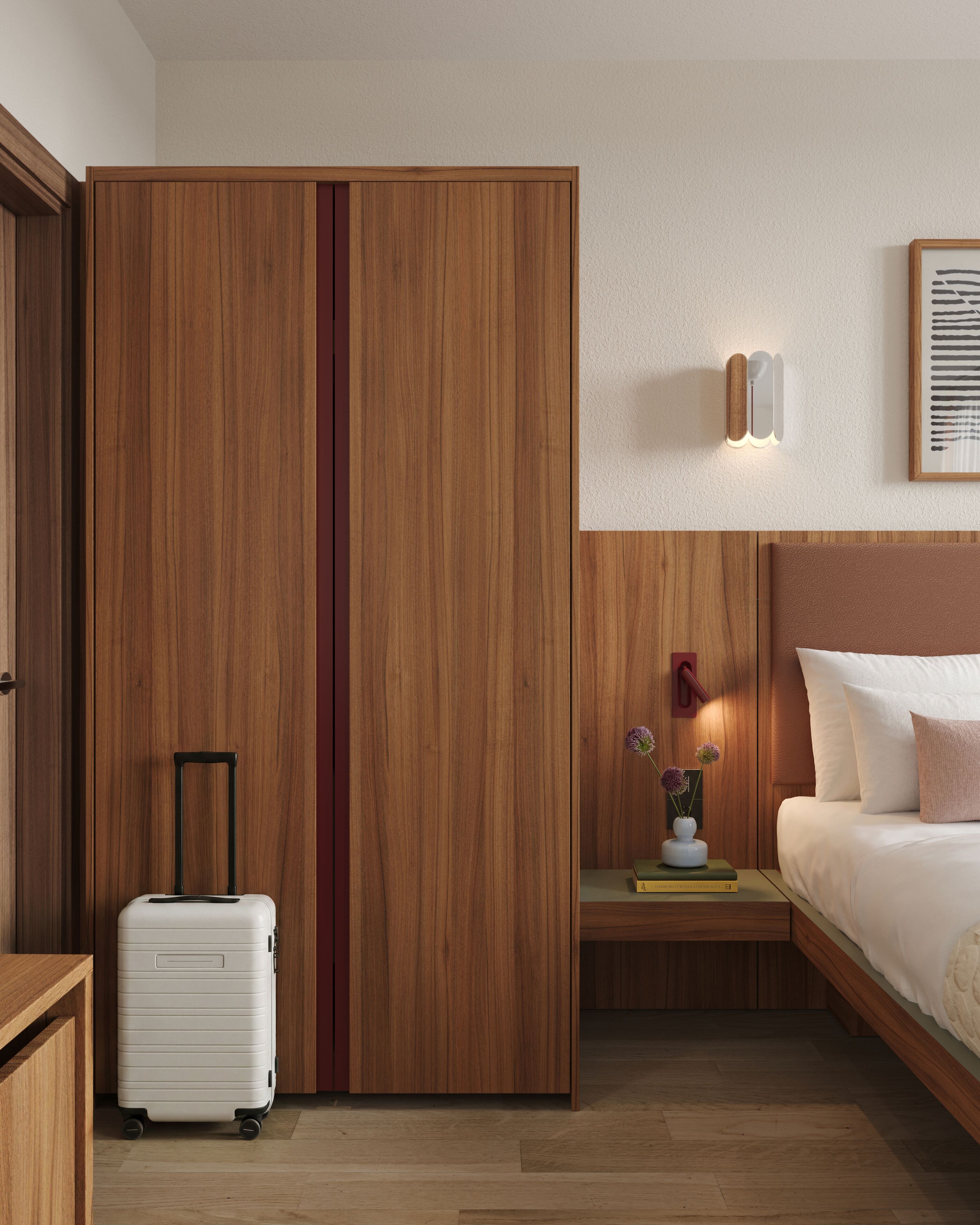 Una camera d'albergo con un'armadio in legno, un letto con biancheria bianca, un comodino con un vaso di fiori e una valigia sul pavimento.
