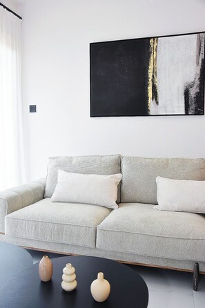A modern living room with a sectional sofa, a black coffee table, and decorative vases. - Luxury City Apartment, 3 bedrooms 3 bathrooms, Chania Center (Chania)