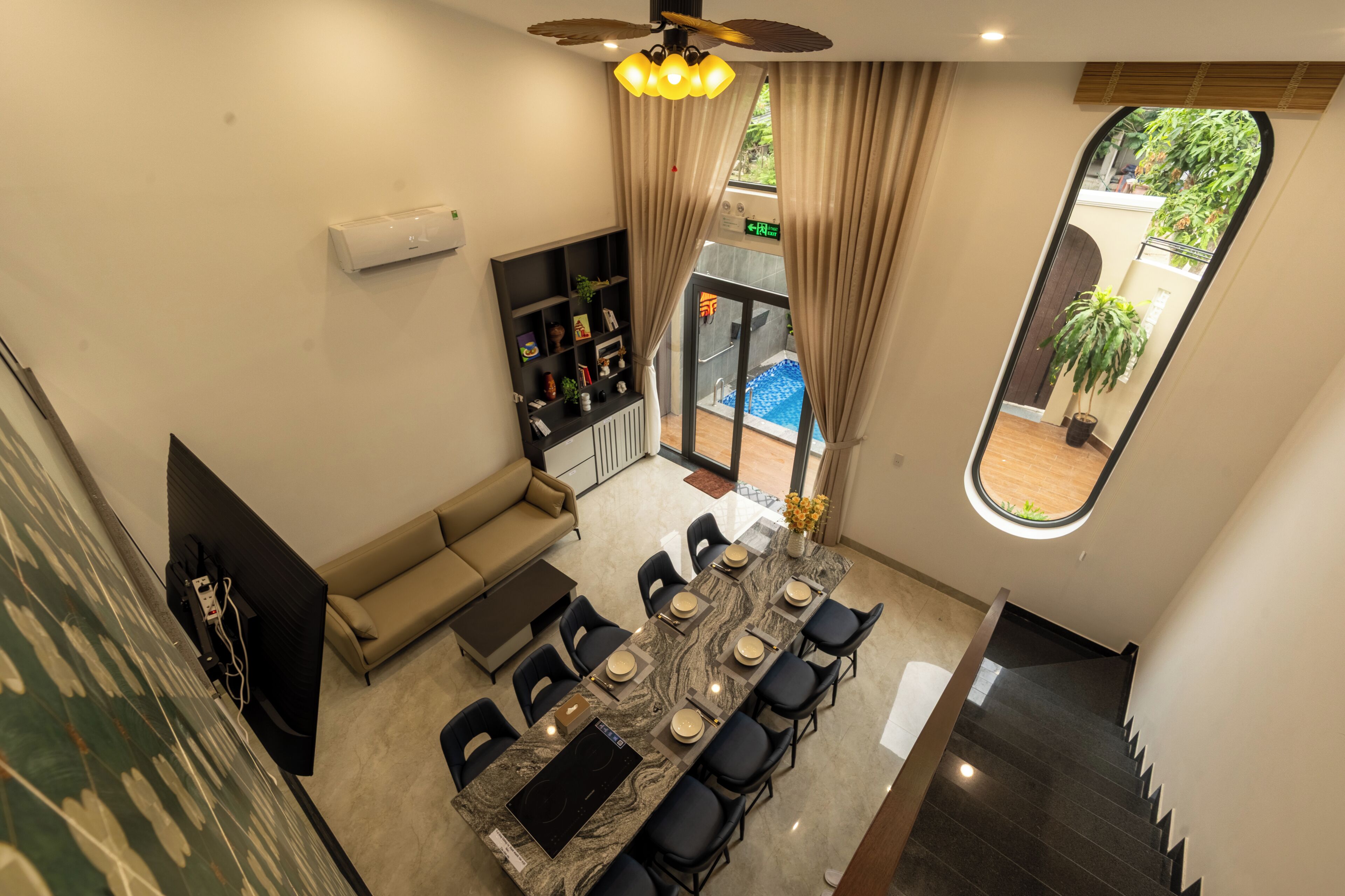 Un comedor con una mesa larga, sillas, un sofá y un televisor.
