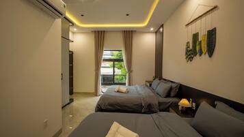 Un dormitorio moderno con dos camas, una mesita de noche, una lámpara y vistas al exterior.