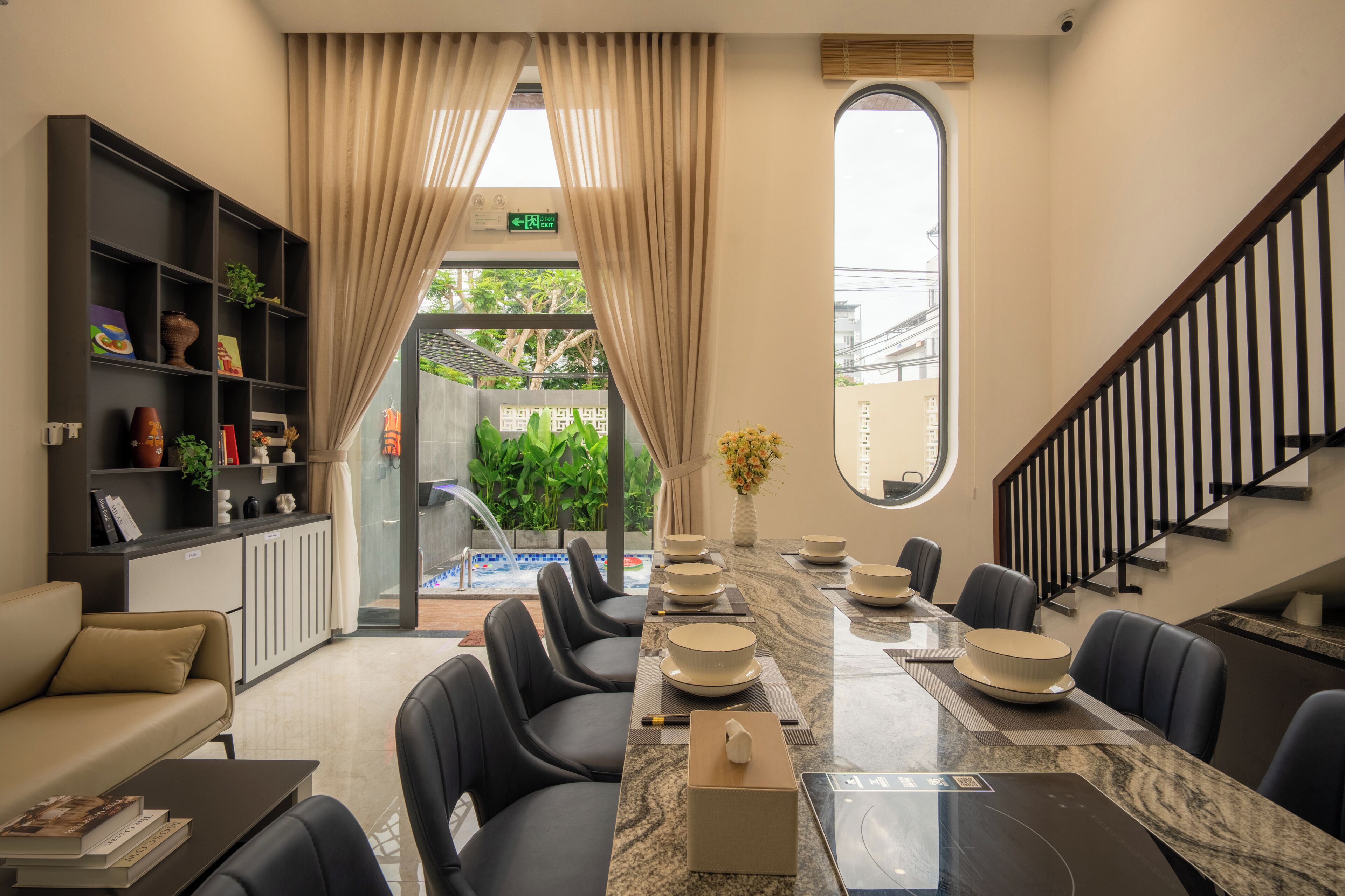 Vestíbulo de hotel con recepción, zona de estar y vistas al exterior.