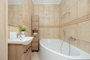 Een moderne badkamer met een vrijstaand bad, een wastafel en een spiegel.