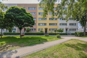 Een meerlaags woongebouw met een geplaveid pad en groen.