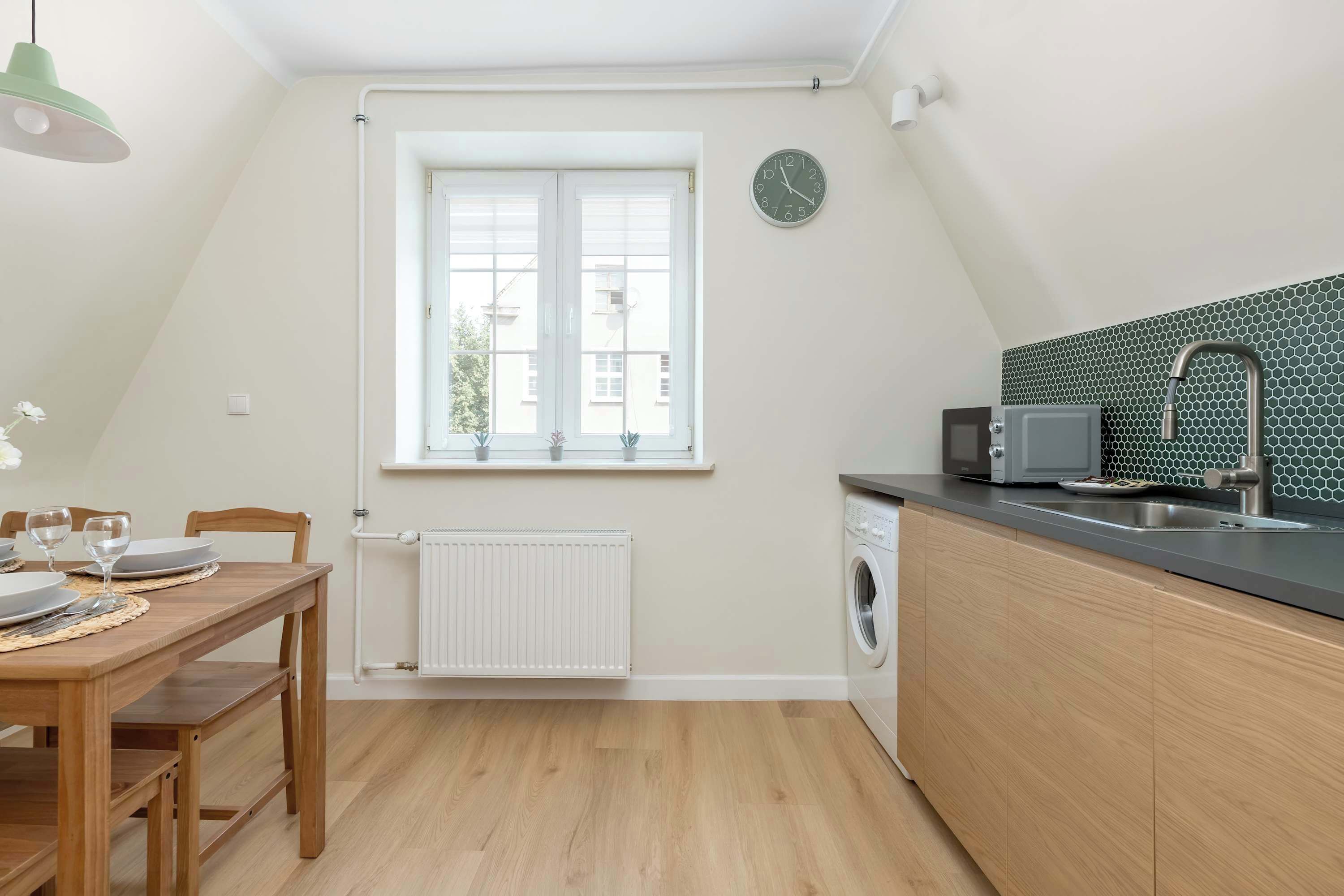 Et moderne køkken med indbygget mikroovn, en vask med hanefaucet og et vindue over bordpladen.
