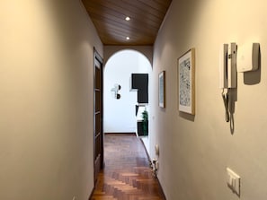 A hallway with wooden flooring, a white wall, and a door on the left. - Città Studi: Two-room apartment near the M2 Piola station (Milan)