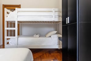 A bunk bed with a ladder, a small bedside table, and a black wardrobe. - Città Studi: Two-room apartment near the M2 Piola station (Milan)