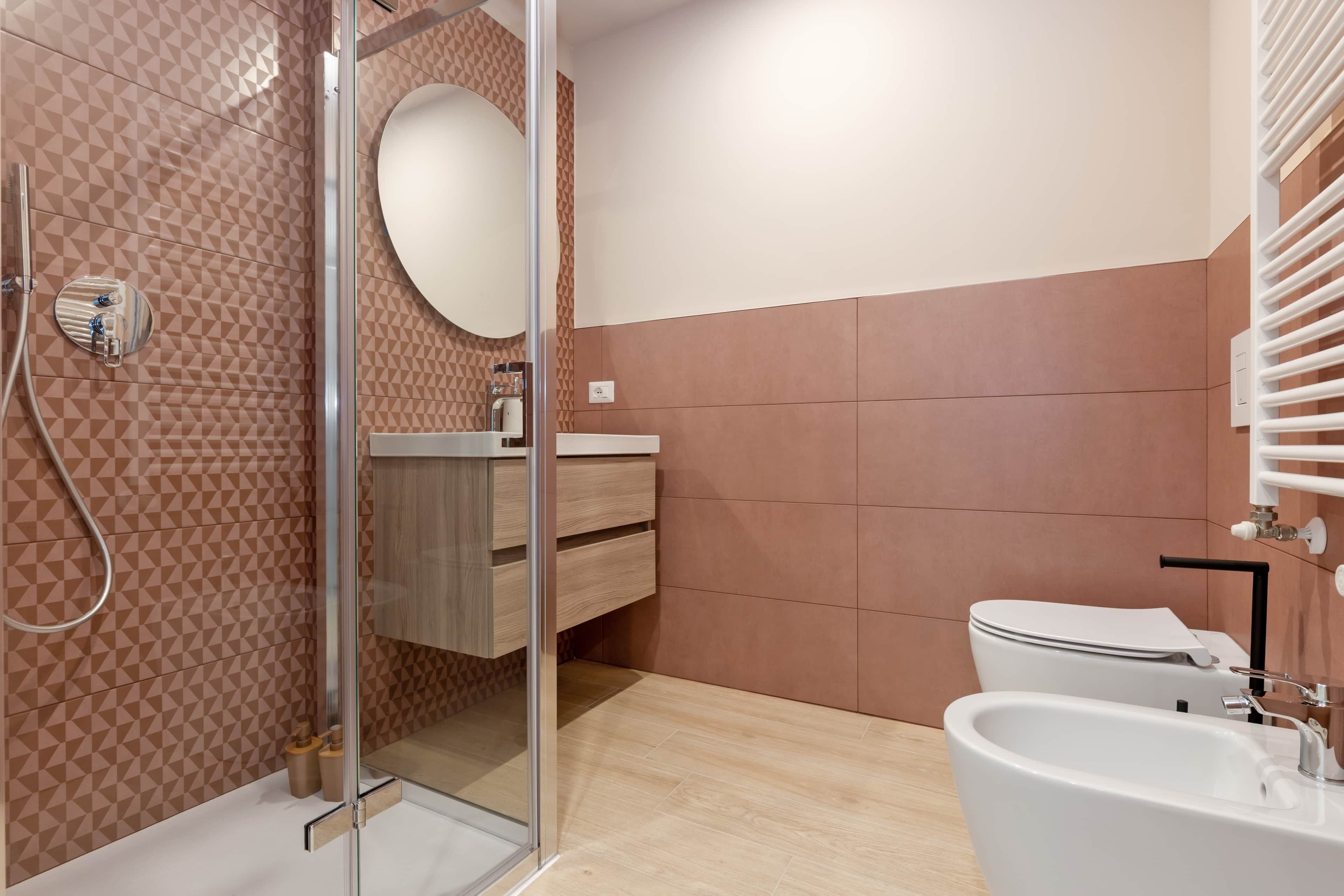Ein modernes Badezimmer mit Duschkabine aus Glas, Waschbecken und Toilette.