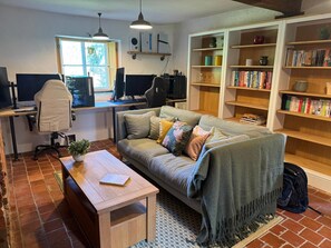 A living room with a sofa, coffee table, and a bookshelf filled with books.