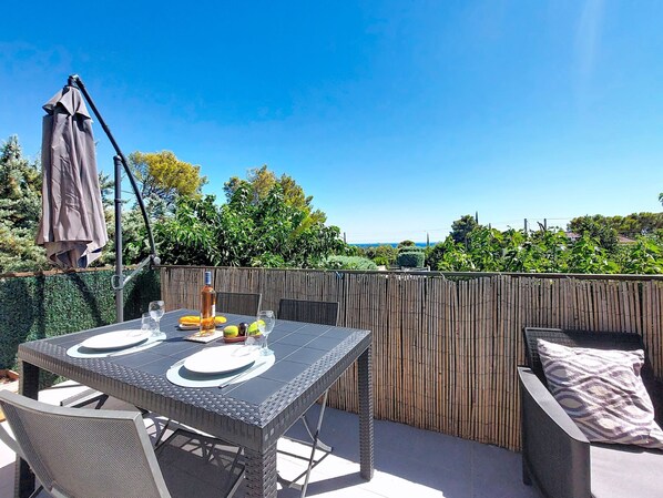 Eine einladende Terrasse mit Tisch für zwei Personen, einem Stuhl und einem Holzzaun.