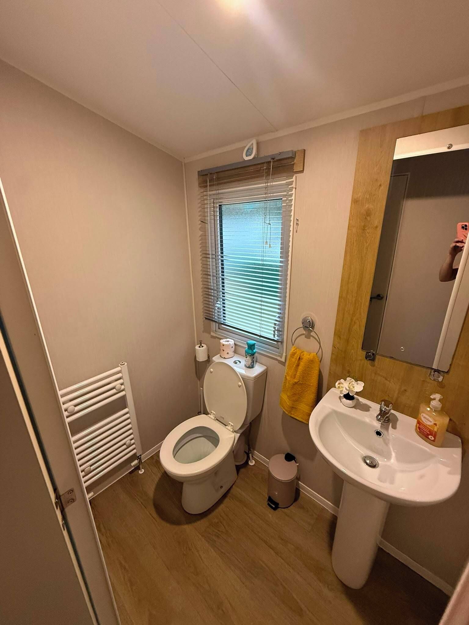 Un baño pequeño con inodoro, lavamanos y ventana.