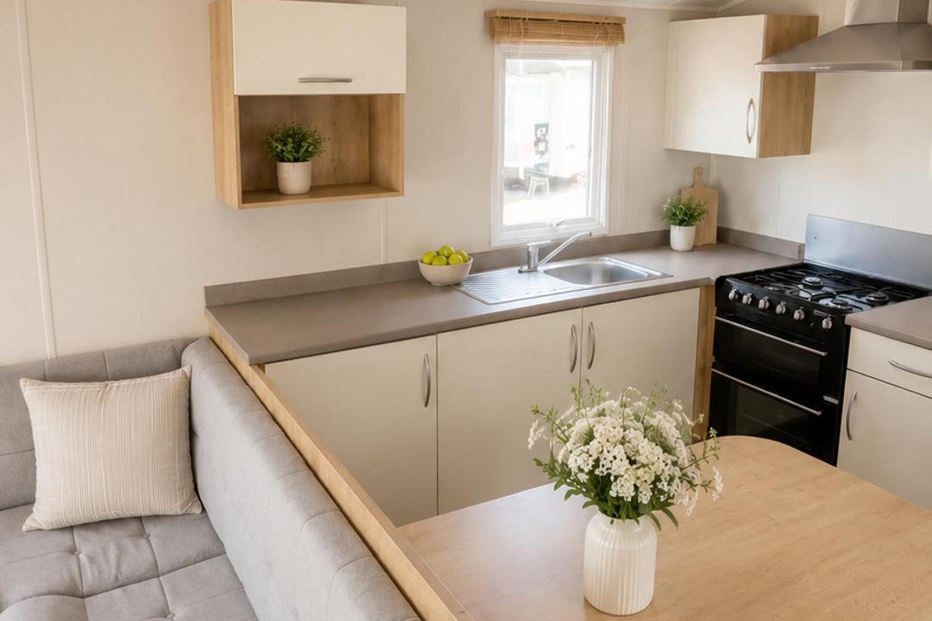 Une petite cuisine équipée avec une cuisinière, un évier et une petite fenêtre.