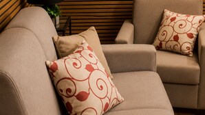 A beige sofa with a patterned pillow and a matching pillow on a wooden slatted wall. - Modern Apartment in Alcamo near in Marina & Castellammare del Golfo (Alcamo)