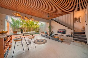 Ein modernes Interieur mit Küche, Essbereich und Wohnbereich inklusive Treppe.