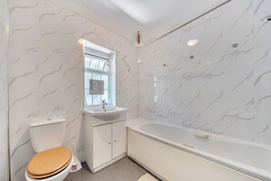 A bathroom with a toilet, sink, and bathtub, all with marble-like wall tiles. - 2-br, Sleeps 4 With Garden Near Uni & Q E Hospital (Birmingham)