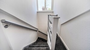 A staircase with a handrail, a window, and a view of the outside. - 2-br, Sleeps 4 With Garden Near Uni & Q E Hospital (Birmingham)