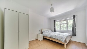 A bedroom with a single bed, a wardrobe, a bedside table, and a window with curtains. - 2-br, Sleeps 4 With Garden Near Uni & Q E Hospital (Birmingham)