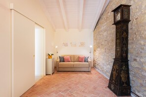 Une pièce avec un canapé beige, une armoire blanche et une horloge murale.