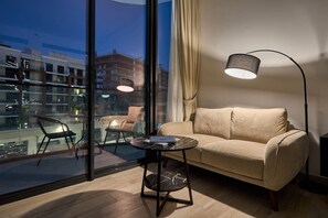 Ein stilvolles Wohnzimmer mit einer Couch, einem kleinen runden Tisch und einer Stehlampe.