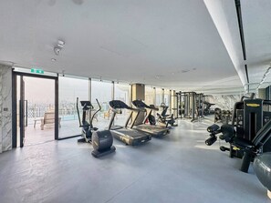 Ein Fitnessstudio mit Laufbändern, Crosstrainern und Gewichten.