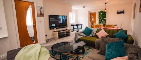 Una sala moderna con un conjunto de sofás, una mesa de centro y una televisión.