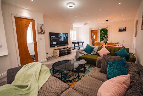 A modern living room with a sofa set, a coffee table, and a television.