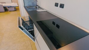 A modern kitchen with a dishwasher, a sink, and a stove. - 09 Relais du Lac Charme - Italian Homing (Desenzano del Garda)