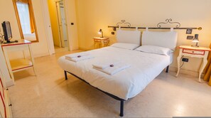 A hotel room with a bed, bedside tables, a desk, a mirror, and a door. - 116 Relais du Lac Village - Italian Homing (Desenzano del Garda)
