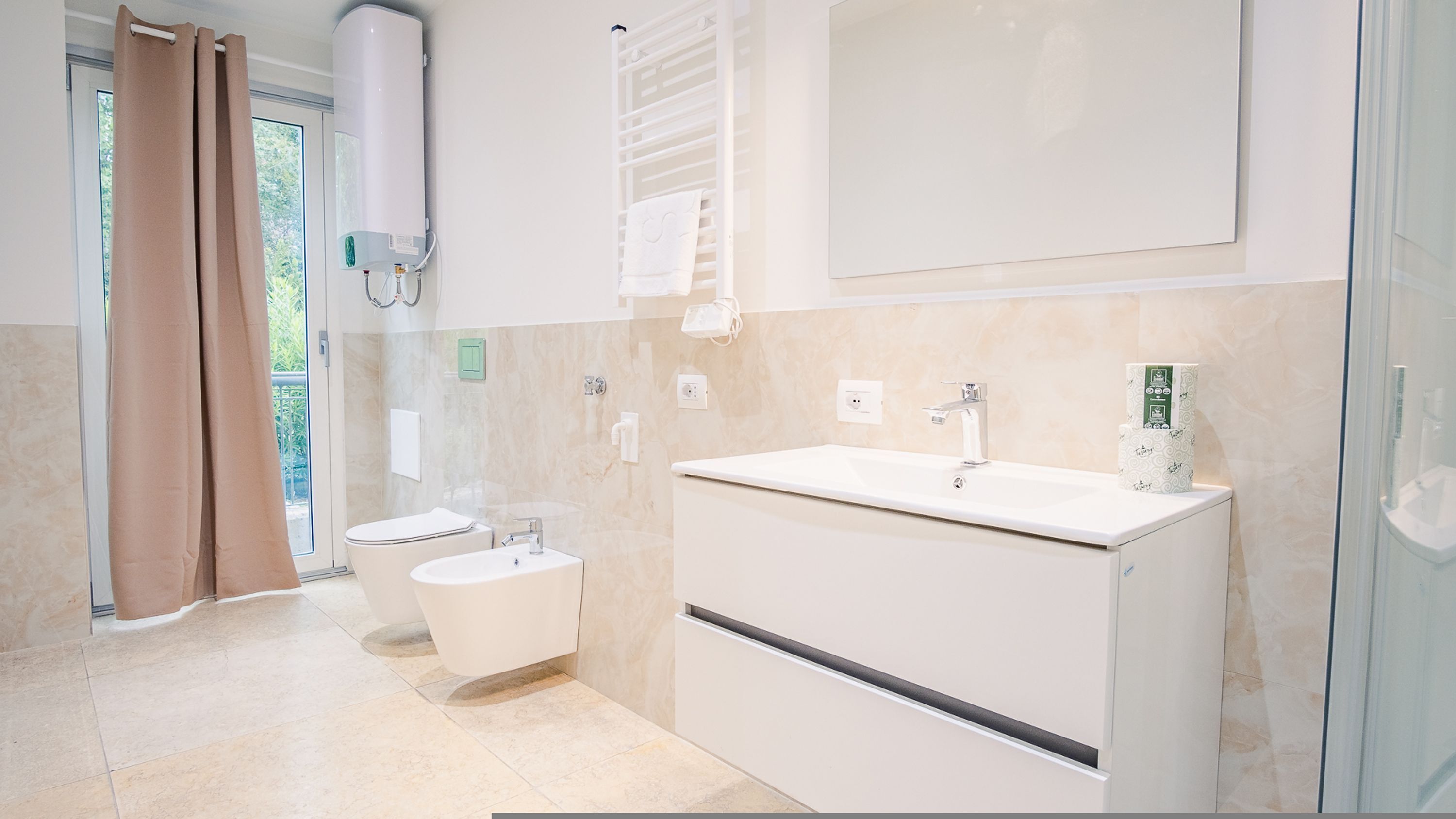 A modern bathroom with a toilet, bidet, and sink.