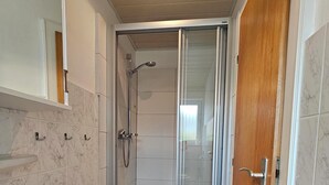 Ein Badezimmer mit Dusche, Badewanne und Toilette.