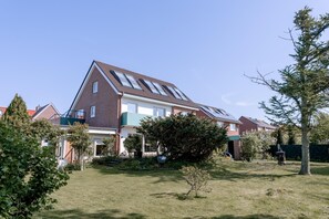 Ein Wohnhaus mit Satteldach, Solaranlage und gepflegtem Rasen.