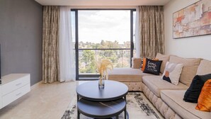 Ein modernes Wohnzimmer mit einer Couch, einem Couchtisch und Blick durch ein großes Fenster.