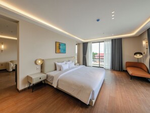 A hotel room with a large bed, bedside tables, a sofa, and a view of the outdoors. - Pinewood Dalat (Lam Vien - Da Lat)