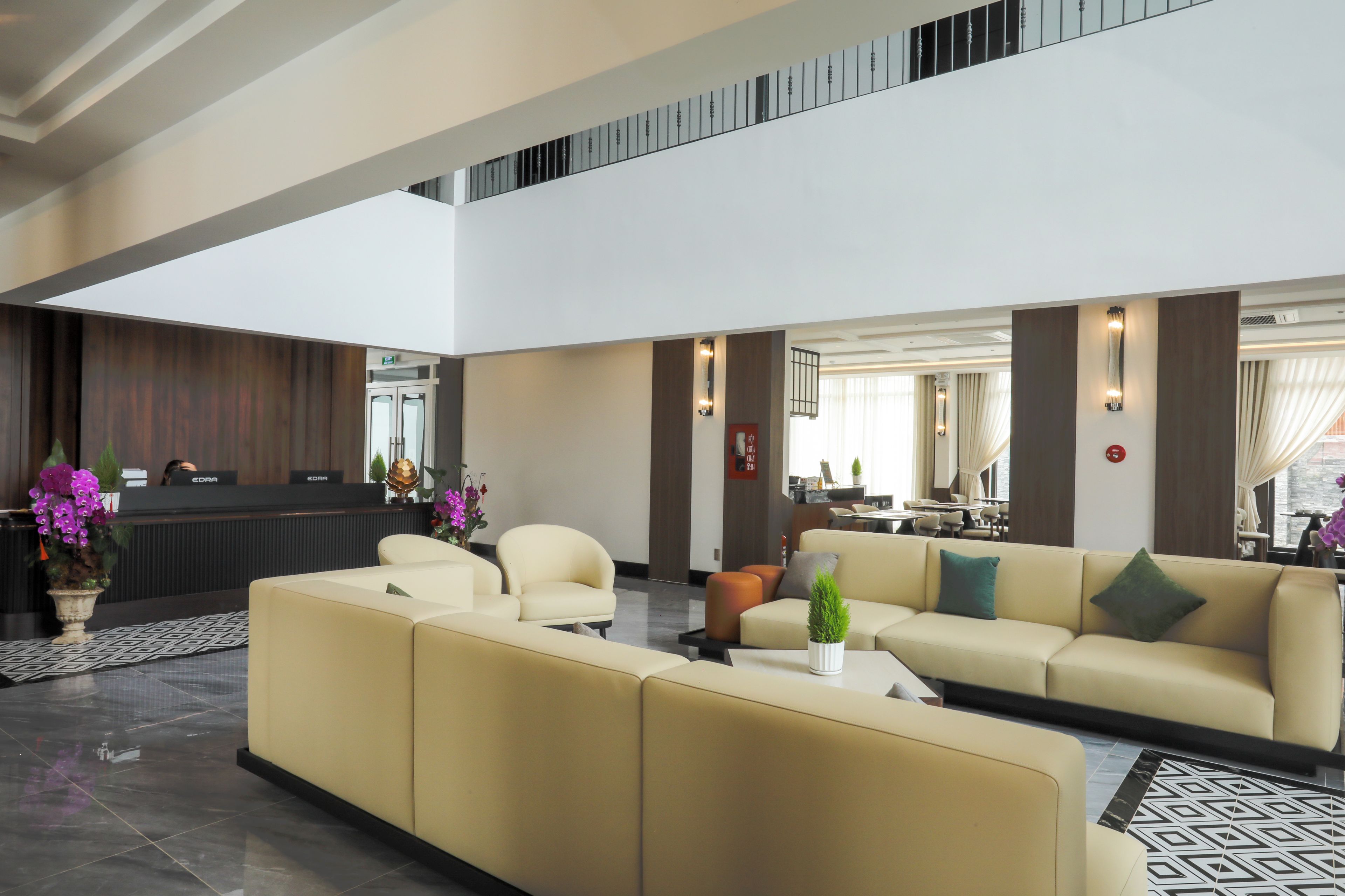 Tilava aula, jossa on vastaanottotiski, sohvia ja kahvila.