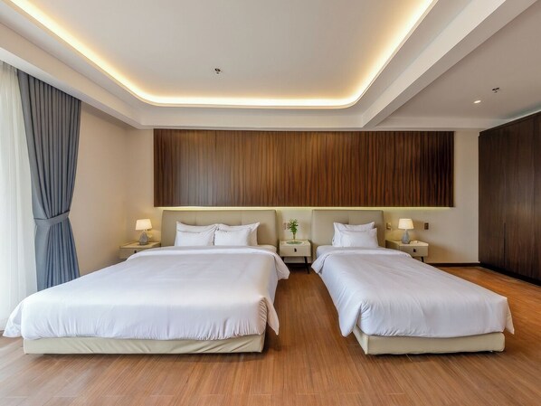 A hotel room with two beds, wooden flooring, and a modern ceiling design. - Pinewood Dalat (Lam Vien - Da Lat)