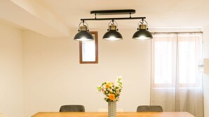 A dining area with a wooden table, six chairs, and three pendant lights. - Les Cariolettes Lodge (Font-Romeu-Odeillo-Via)
