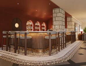 A bar area with a curved wooden bar, multiple bar stools, and a patterned floor.